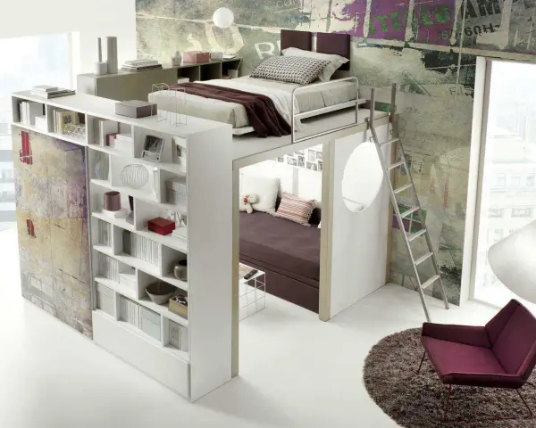Arredamenti camerette moderni: letto soppalcato con libreria integrata e zona relax sottostante, scala a pioli, poltrona e tappeto.