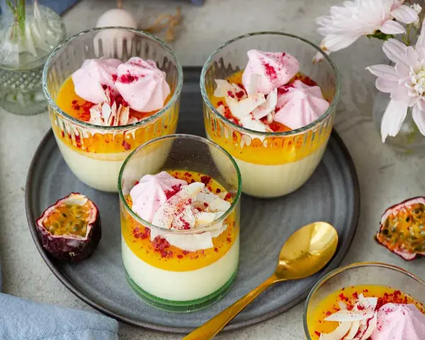 Vackra glas med pannacotta påsk, toppad med passionsfruktscurd, maräng och kokosflingor. En festlig dessert!
