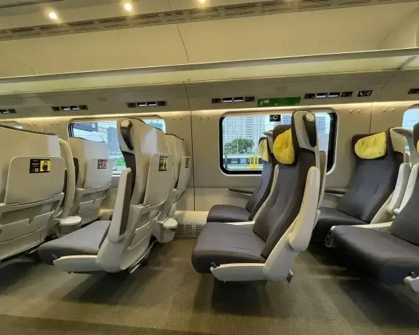 Wnętrze pociągu z wygodnymi fotelami. Czy EIP to Pendolino? Tak, to nowoczesne wagony klasy pierwszej.