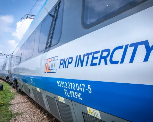 Pociąg PKP Intercity z niebieskim pasem i logo.