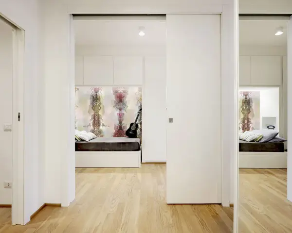 Un letto a scomparsa e una porta scorrevole creano una stanza in più, trasformando un corridoio in uno spazio accogliente.