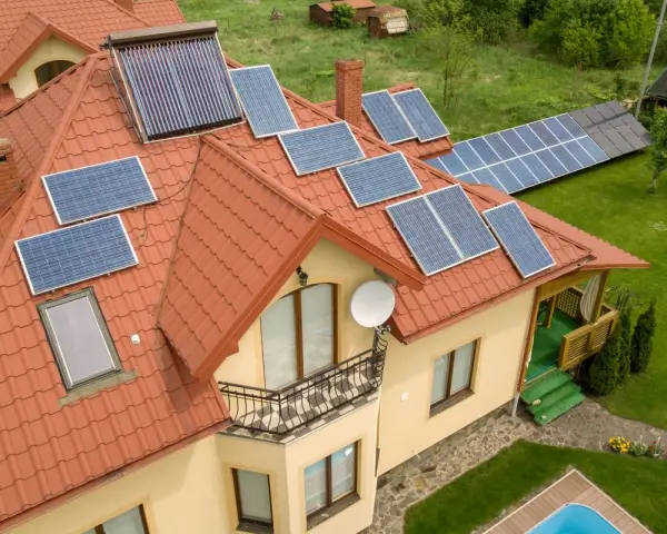 Dom z panelami fotowoltaicznymi na dachu. Instalacja fotowoltaiczna to inwestycja, która pozwala na odliczenie fotowoltaiki od podatku, obniżając rachunki.