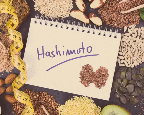Czy hashimoto skraca życie? Notatnik z napisem "Hashimoto", taśma miernicza i zdrowe nasiona.