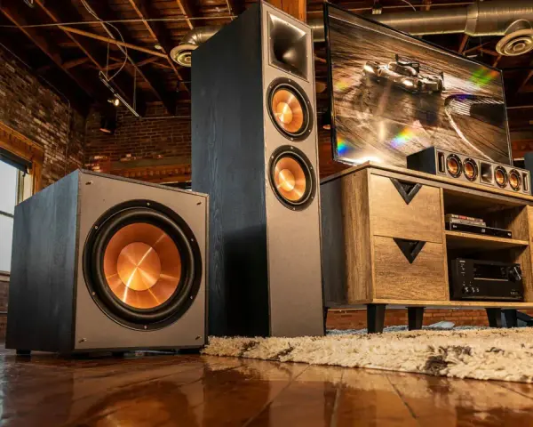 Idealne ustawienie subwoofera i głośników w industrialnym salonie. Ciemne kolumny i subwoofer z miedzianymi membranami tworzą stylowy zestaw audio.