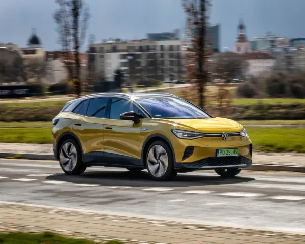 Żółty VW ID.4 jedzie po mieście, pokazując swój imponujący zasięg.