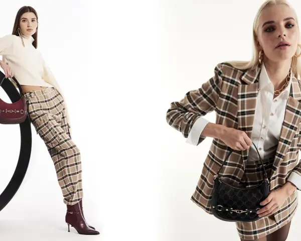 Due modelli mostrano idee outfit ufficio inverno: uno con maglione a collo alto, pantaloni a quadri e borsa bordeaux; l'altro con blazer a quadri, camicia bianca e borsa nera.