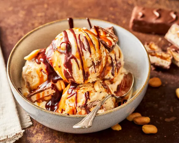 Schokoladiges Eis mit Karamell und Erdnüssen, perfekt für alle, die Snickers Eis selber machen wollen.