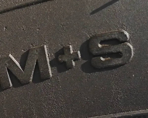 Napis "M+S" na bieżniku opony, oznaczający gotowość na błoto i śnieg.
