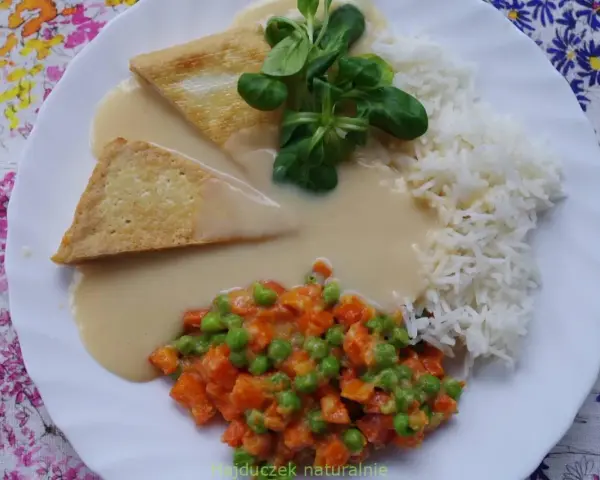 Trójkątne kawałki tofu w kremowym sosie madras, podane z ryżem i warzywami.