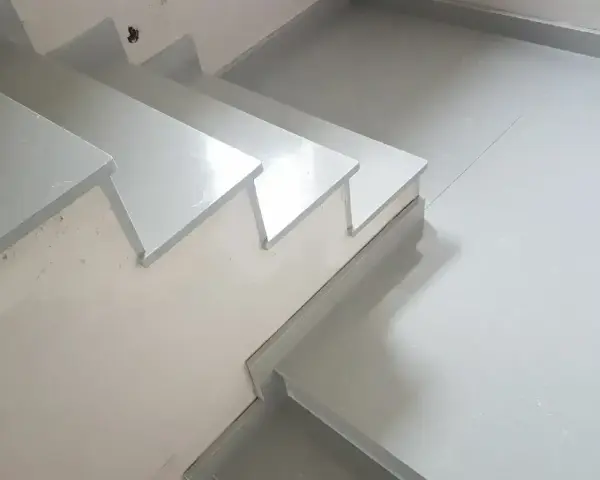 Nowoczesne schody z aglomarmuru w jasnym kolorze, idealne do minimalistycznych wnętrz.