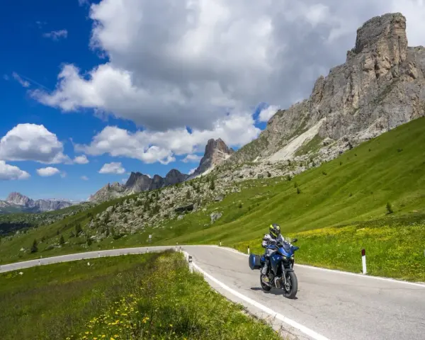 Motociclista su strada panoramica tra le montagne, un invito a scoprire le **strade da fare in moto** con panorami mozzafiato.