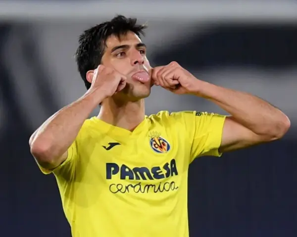 Gerard Moreno, jugador del Villarreal, celebra un gol con un gesto divertido, sacando la lengua y tocándose las mejillas.