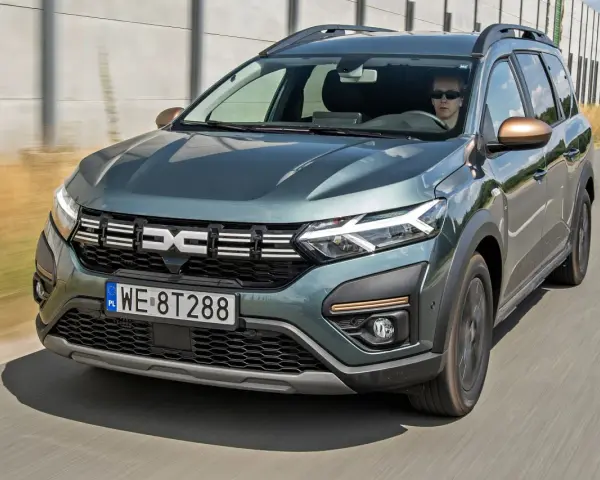 Dacia Jogger w zielonym kolorze jedzie po drodze. Sprawdź atrakcyjną dacia jogger cena i wybierz swój wymarzony samochód.
