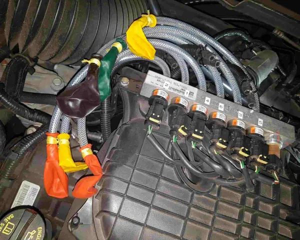 Motorkomponenten mit bunten Ballons an Leitungen. Mögliche Symptome eines defekten Benzinpumpenrelais sind hier zu sehen.