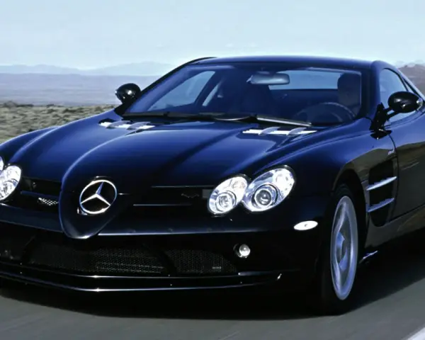 Czarny SLR McLaren pędzi po pustynnej drodze, jego sylwetka lśni w słońcu.