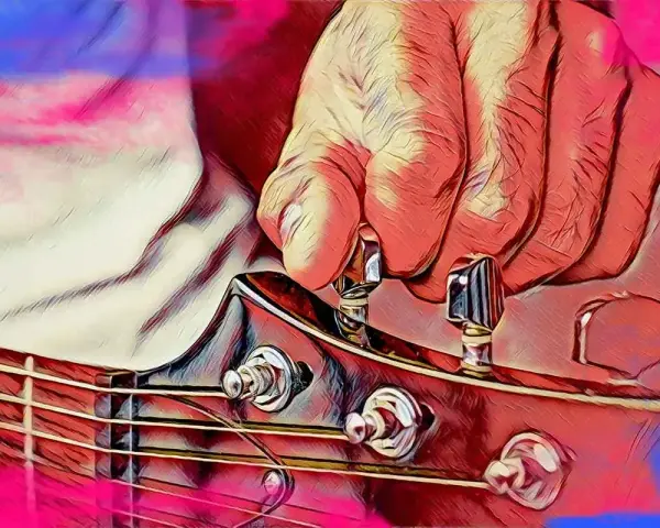 Dłoń stroi gitarę, naciągając struny do idealnego dźwięku a 440 hz.