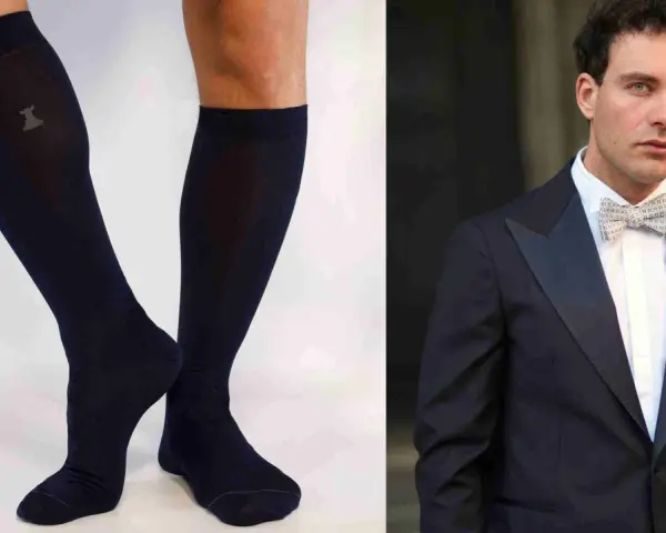Un uomo elegante con smoking e papillon abbinato a calzini scuri.
