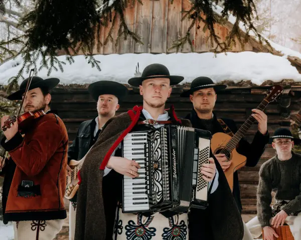 Zespół weselny gra na skrzypcach, akordeonie, gitarze i basach. Muzycy w tradycyjnych strojach góralskich.