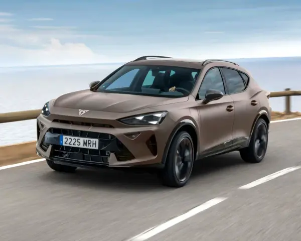 Brązowy SUV Cupra jedzie po drodze nad morzem.
