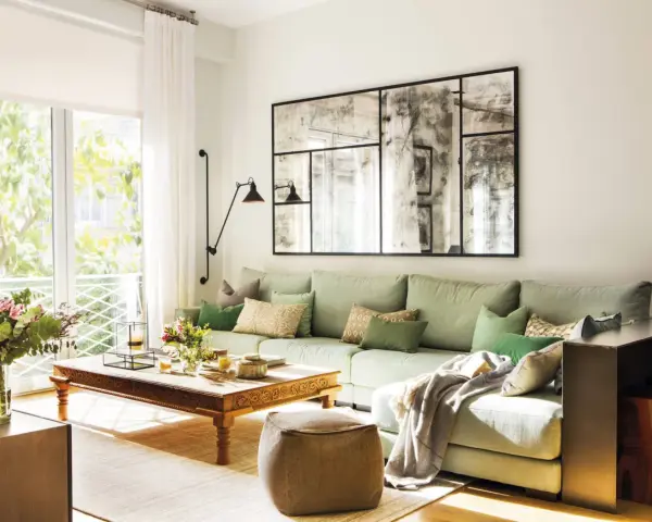 Un espejo grande y decorativo es una excelente idea de qué poner detrás del sofá, aportando amplitud y estilo a la sala.