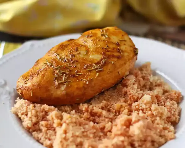 Deliziosi fusi di pollo in friggitrice ad aria, dorati e profumati al rosmarino, serviti su un letto di couscous.