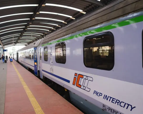 Pociąg PKP Intercity na peronie, z widocznymi oknami i logo.