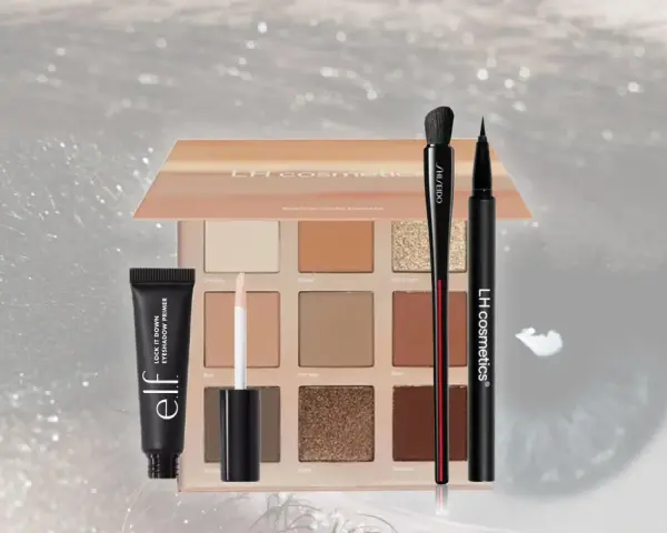 Make-up Produkte: Lidschattenpalette, Primer, Pinsel und Eyeliner auf glitzerndem Hintergrund.