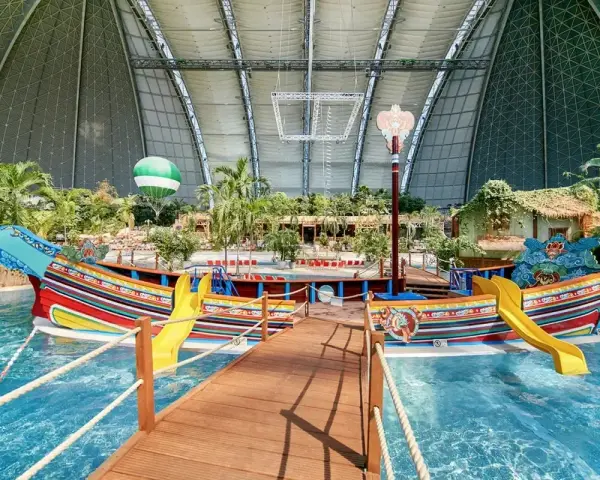 Kolorowy statek z żółtymi zjeżdżalniami w tropikalnym basenie. Idealne miejsce na wakacje, sprawdź bilety na tropical islands!