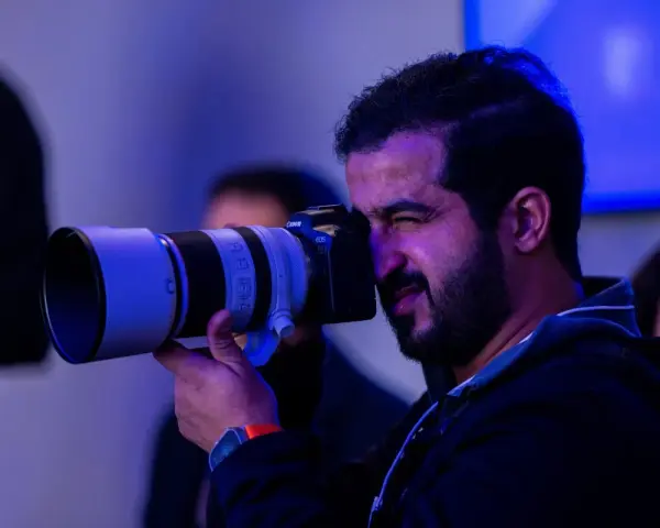 Un fotografo con una Canon EOS scatta foto, pensando a quanto guadagna un fotografo.