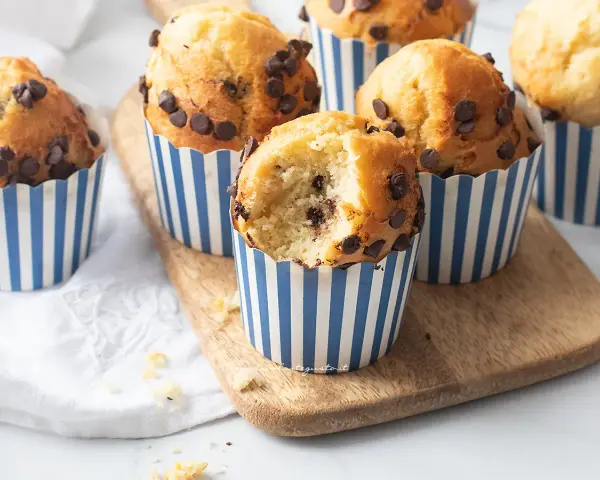 Muffin in friggitrice ad aria con gocce di cioccolato, uno è stato morso rivelando un interno soffice.