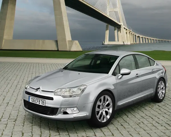 Srebrny Citroen C5 na tle mostu. Wiele osób chwali ten model, a opinie o Citroen C5 są zazwyczaj pozytywne.