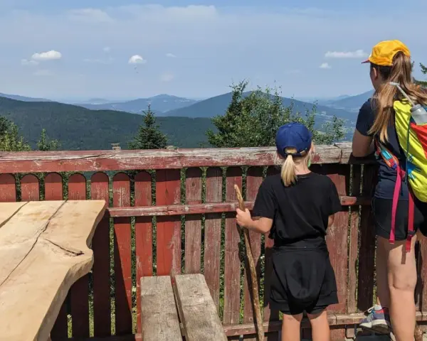 Dwie dziewczynki podziwiają malownicze widoki z tarasu. To idealne miejsce na odkrywanie widokowych szlaków blisko Krakowa.