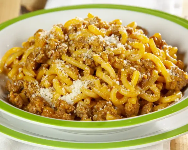 Piatto di gramigna alla salsiccia, condita con ragù saporito e una spolverata di parmigiano.