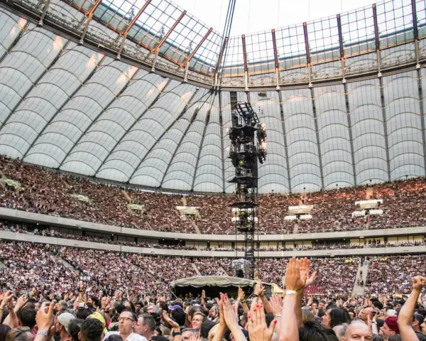 Roztanczony PGE Narodowy w Warszawie, tłumy ludzi na koncercie pod dachem stadionu.