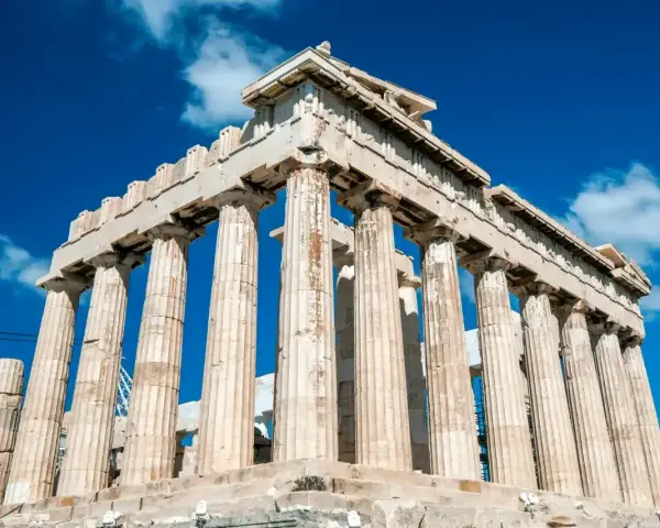 Le Parthénon, temple d'Athéna, se dresse majestueusement sous un ciel bleu éclatant, ses colonnes doriques témoignant de la grandeur de l'Acropole d'Athènes.