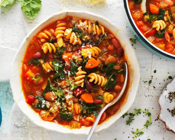 Aksamitna zupa minestrone z makaronem, fasolą i warzywami, posypana parmezanem. Idealna na chłodne dni.
