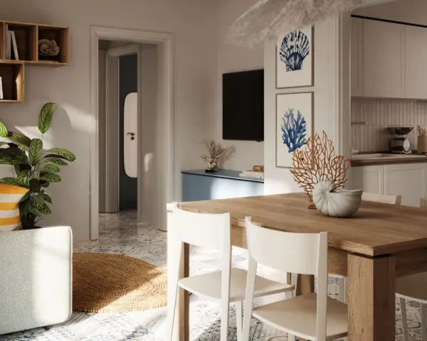 Tavolo in legno con sedie bianche, decorazioni marine e quadri a tema conchiglie: idee originali per arredare casa al mare.