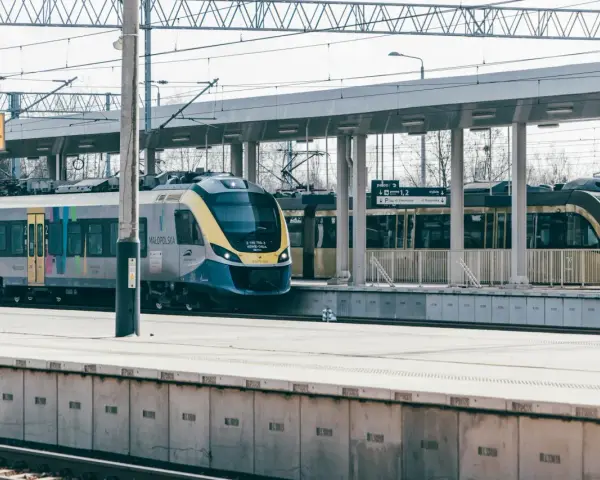 Nowoczesny pociąg Małopolska na stacji. Uważaj na znaki ostrzegawcze, by uniknąć opłaty manipulacyjnej i niebezpieczeństwa.