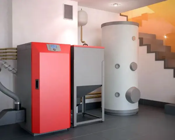 Instalación moderna para cambiar caldera de gas por pellets. Caldera roja, depósito de pellets y acumulador de agua.