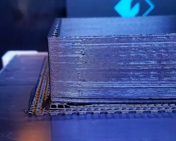 Drukarka 3D tworzy obiekt z czarnego materiału PEEK, warstwa po warstwie.
