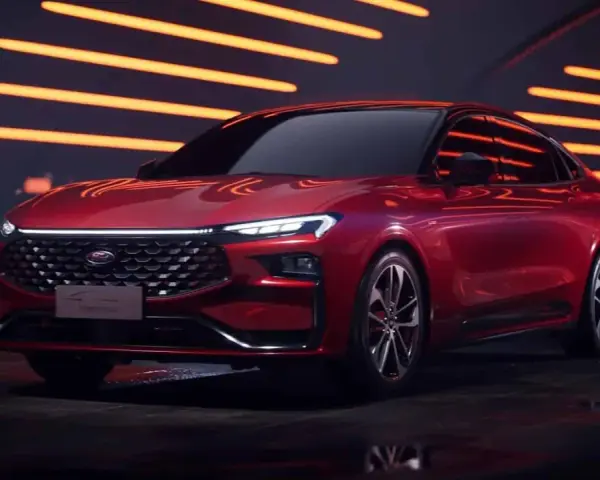 Czerwony Ford Mondeo MK6 z nowoczesnym designem, błyszczącym grillem i ostrymi światłami LED, prezentowany na tle pomarańczowych świateł.