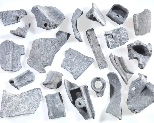 Kawałki metalu, gotowe do recyklingu metalu. Różnorodne kształty i rozmiary, niektóre z otworami, świadczą o ich przemysłowym pochodzeniu.