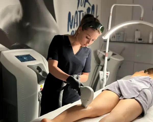 Profesjonalistka wykonuje zabieg depilacji laserowej nogi. To najlepszy laser do depilacji, zapewniający gładkość skóry.