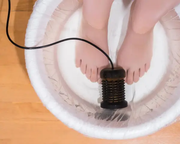 Feet in a detox foot bath with an ionizer. This setup is often used in a detox foot bath recipe for relaxation and cleansing.