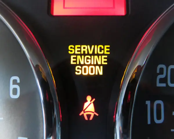 Dashboard lights show "SERVICE ENGINE SOON" and a seatbelt warning. This is a common indicator that it's time to figure out how to reset check engine light.