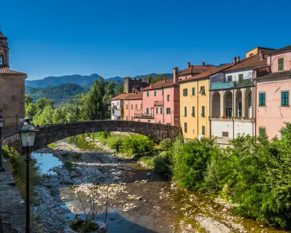 Pontremoli, dove si trova questo pittoresco borgo con case colorate, un ponte ad arco e un fiume.