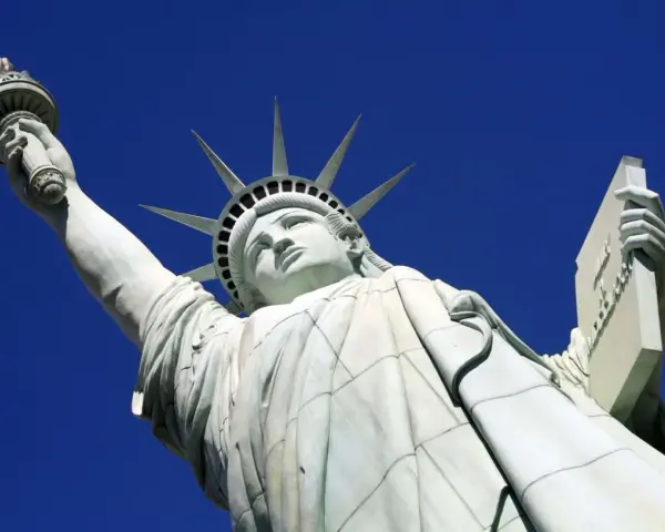 La Statue de la Liberté, une femme emblématique, lève sa torche vers le ciel. Elle porte une tablette, symbole de la loi.