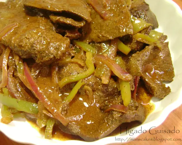 Hígado guisado con cebolla y pimientos verdes en salsa marrón.