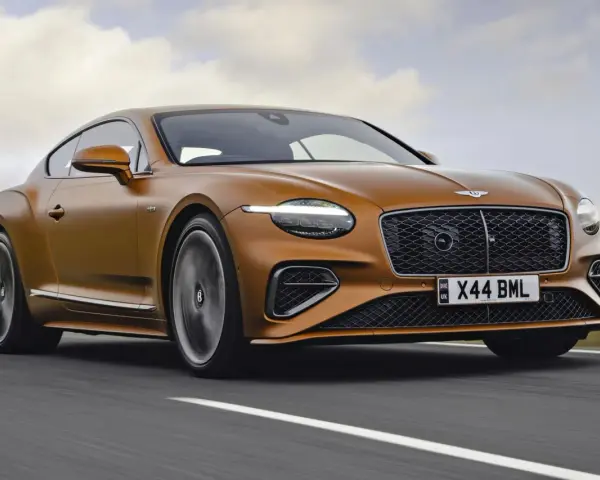 Pomarańczowy Bentley Continental GT na drodze. Sprawdź aktualną bentley cena i poczuj moc.