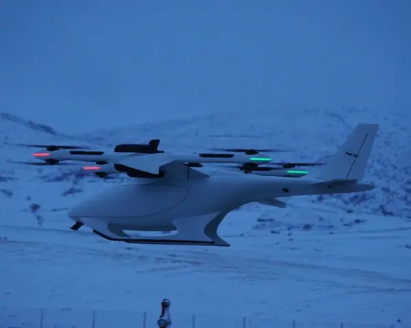 A white vtol drone with red and green lights flies over a snowy landscape at dusk.